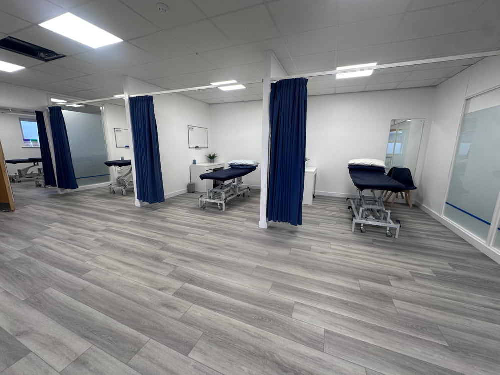 Cubicle curtain track installation in a physiotherapy clinic with navy curtains