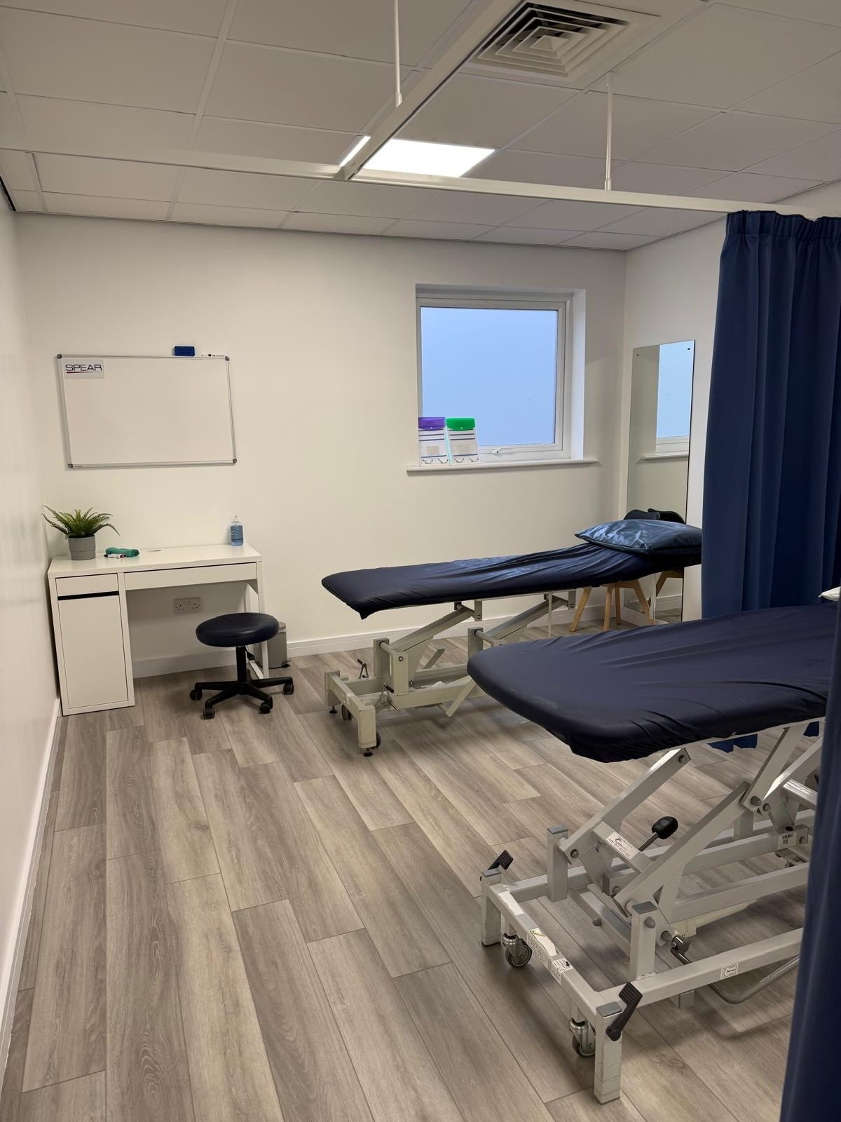 Private treatment room with cubicle curtains around examination couches